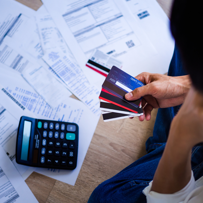 Someone looking at their credit card bills to represent 'help with credit card debt'