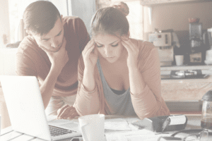 Young-couple-reading-debt-letters-next-to-laptop
