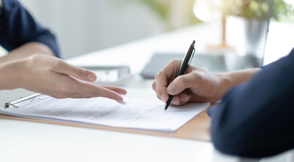 Two people signing a contract discussing whether you can change your iva company or not