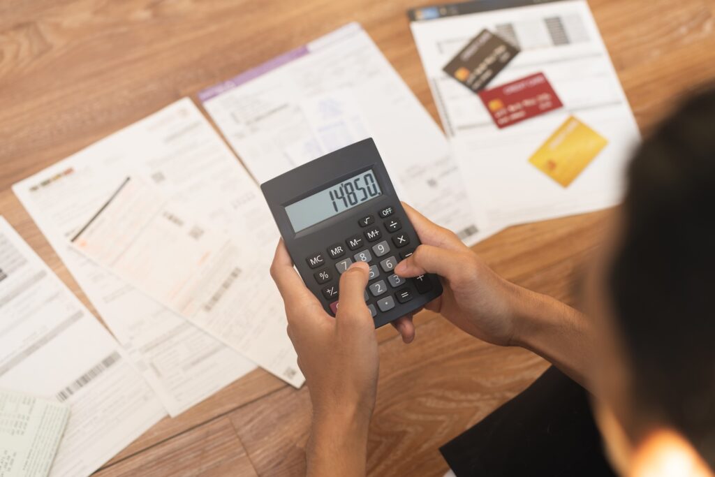 A person working out their debts to represent uk debt statistics for 2025.