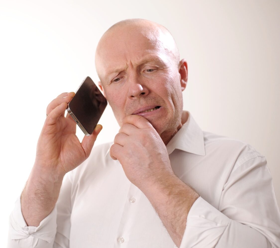 A man in debt on the phone to Cabot Financial debt recovery services