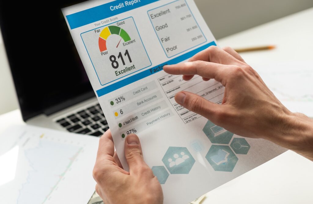 Man holding paper with credit report letters near laptop checking how long does a default stay on your credit file